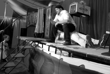 Freakshow Foley on the bed of nails with Ses Carny applying extra pressure (This photograph is © 2005 by James G. Mundie; reproduction without express permission is prohibited.)